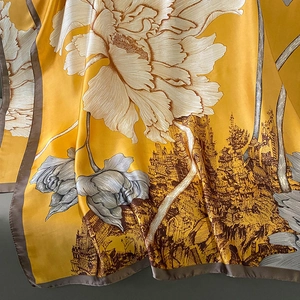 Close-up of yellow silk scarf featuring white floral prints and vintage architecture