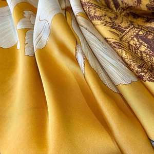 Macro detail of mustard yellow satin scarf featuring vintage floral and architectural prints