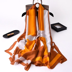 Macro detail of elegant orange and brown geometric silk scarf with satin finish