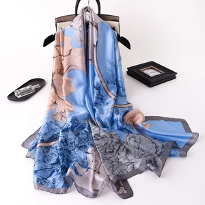 Detailed shot of a floral landscape print silk scarf draped elegantly on a hanger