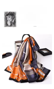 Detail of elegant orange and grey chain pattern silk scarf draped over a white handbag