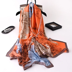 Close-up of elegant floral silk scarf with vintage orange and blue prints and rolled edges
