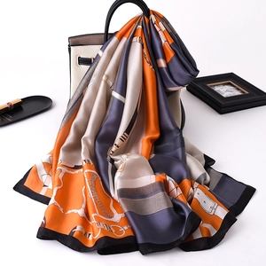 Close-up of silk scarf with equestrian chain pattern draped on a handbag strap