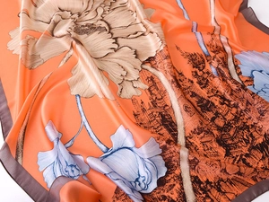 Close-up of silk scarf with orange tones, floral patterns and classical architecture