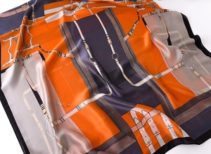 Detail of orange luxury silk scarf with chain pattern and satin fabric texture