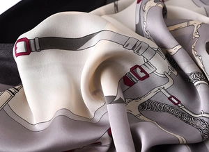 Detail shot of elegant chain pattern silk scarf with soft fabric texture and grey tones