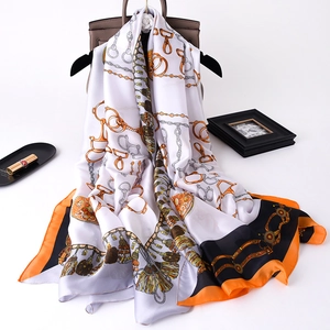 Detail of silk-like satin scarf with classic horse harness print on a designer bag