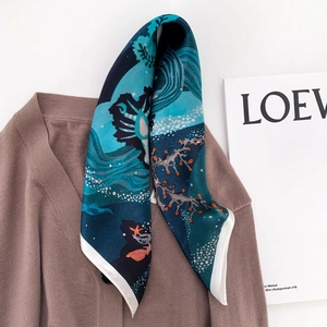 Detailansicht eines Twilly-Seidenschals mit Meeresprint auf einem V-Pullover