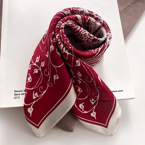 Detailansicht des Seidenquadrats mit floraler Weinreben-Textur auf weinrotem und creme Stoff