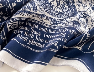 Detail eines Seidenschals mit Vintage-Illustration und gotischem Text auf Satin
