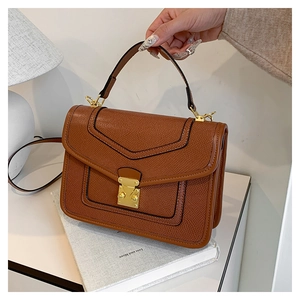 Detailed view of brown lychee texture leather handbag with elegant gold square lock