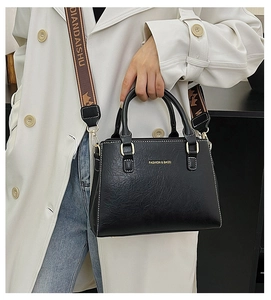 Detail of black lychee grain texture tote with a wide jacquard patterned strap