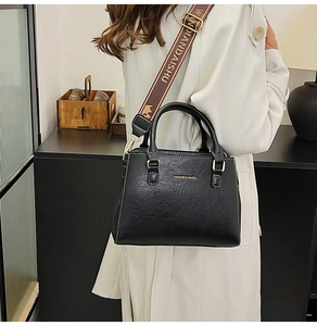 Detail of black medium tote bag with retro wrinkled texture and wide branded strap