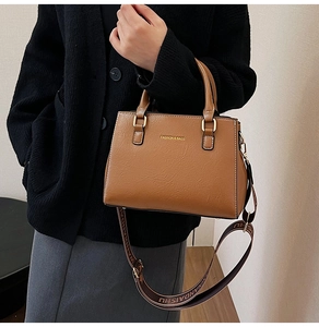 Close-up of brown textured leather tote with fashion printed wide shoulder strap