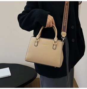 Detail of beige faux leather tote with litchi texture and printed wide shoulder strap