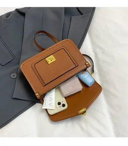 Detail of vintage brown pebble leather bag showing interior capacity and golden lock