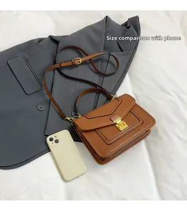 Brown vintage flap shoulder bag shown with a white iPhone for size comparison