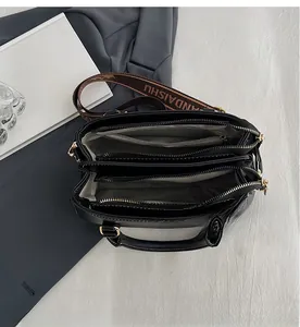 Internal view showing multiple zipper compartments and textured lining of the black leather bag