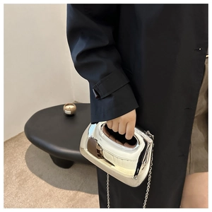 Close-up of pebble-shaped silver metallic clutch bag with polished mirror finish and chain