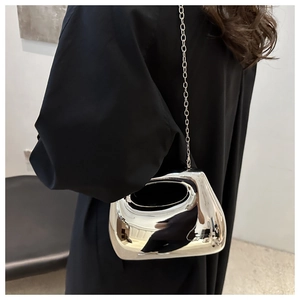 Detail of silver mirror acrylic evening bag with hollow handle and metallic chain strap