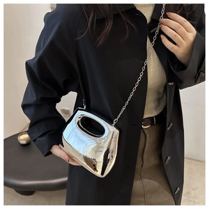 Silver metallic mini crossbody bag with a futuristic mirror finish and slim chain strap