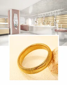 Dettaglio di un bracciale a fascia in oro plissettato su pietra con sfondo di negozio