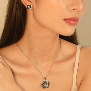 Parure de bijoux géométriques avec collier et boucles d'oreilles portés par un mannequin
