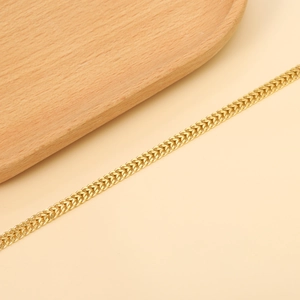 Elegant 18K gold plated stainless steel curb chain bracelet on a minimalist wooden tray