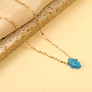 Golden Hamsa necklace featuring a vibrant blue opal pendant on a fine link chain