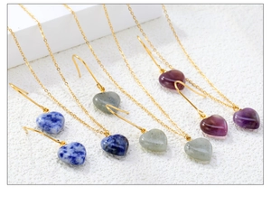 Detailed macro view of heart-shaped natural stone earrings in blue, gray and purple hues