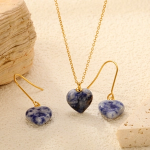 Vintage gold heart necklace and earring set with blue marble stone on natural stone decor