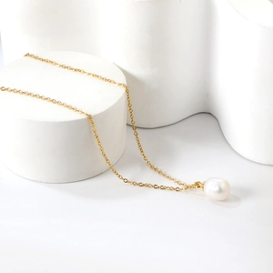 Detail shot of a large white freshwater pearl pendant on a delicate gold stainless steel chain