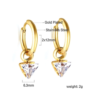 Détail de boucles d'oreilles créoles en acier doré avec zircons triangulaires blancs