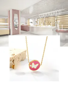 Macro shot of gold stainless steel necklace and earrings with pink butterfly motifs
