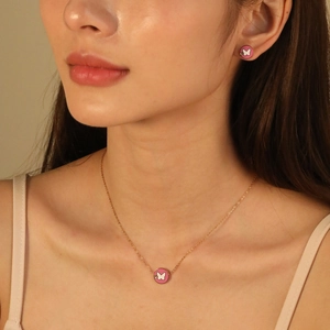 Pink butterfly necklace and stud earrings set in rose gold finish worn by a model