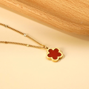 Elegante collana dorata con ciondolo a fiore di pesco rosso e piccoli dischi opachi