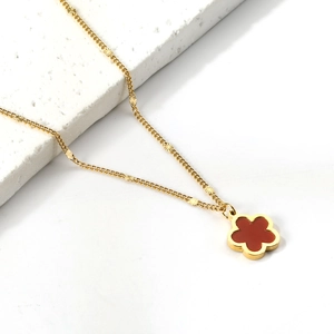 Elegante collana in acciaio dorato con ciondolo a fiore rosso e piccoli dischi testurizzati