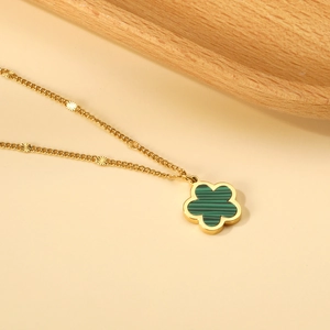 Collana a fiore dorato con ciondolo in malachite e perle sfaccettate su catena fine