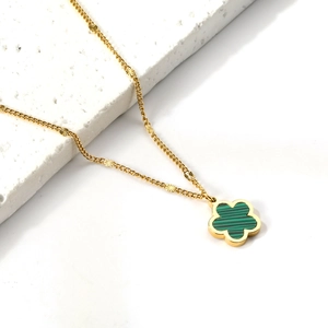 Elegante collana dorata con ciondolo a fiore verde su pietra bianca stile lusso