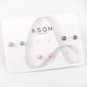 Trois paires de boucles d'oreilles Evil Eye en émail bleu et rose sur carte blanche