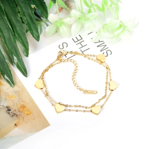 Detail of a gold double-layer heart bracelet with lobster clasp and K14 metal tag