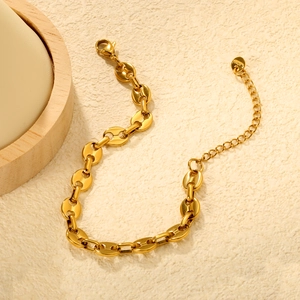 Bracelet à maillons en acier inoxydable doré avec design de chaîne grain de café sur fond beige