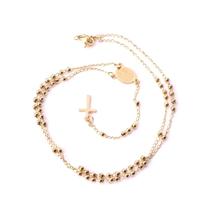 Détail du collier à perles dorées avec pendentif croix et médaille ovale gravée