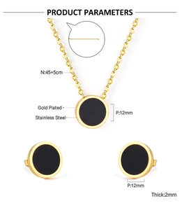 Macro detail of gold stainless steel jewelry set with black round shell inlays