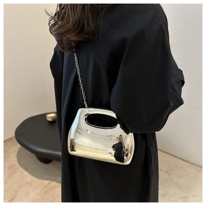 Close-up of silver mirror acrylic box bag with unique oval handle and metal chain