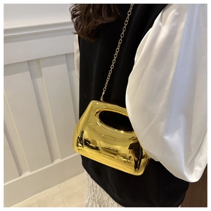 Detail view of gold mirror acrylic handbag with metallic chain and cut-out handle