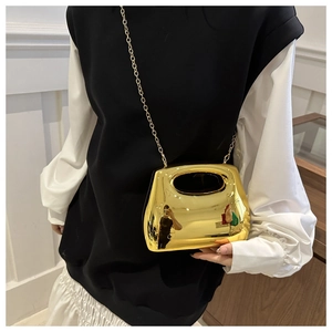 Detailed shot of a gold mirror-finish acrylic clutch with chain and cutout handle