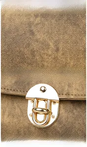 Detailed view of brown twill fabric texture and premium light gold metal buckle closure