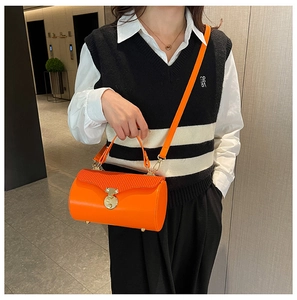 Detail of orange cylinder handbag with wave texture leather and golden circular lock