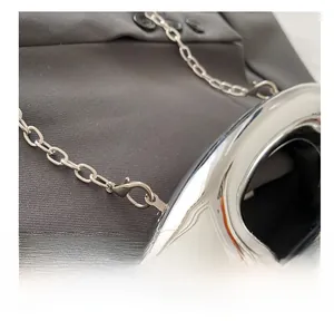 Macro shot of durable silver metal lobster clasp and thick chain strap on crossbody bag